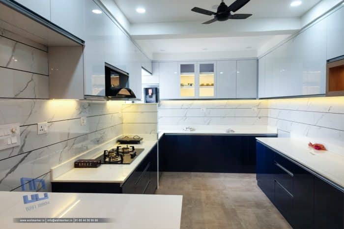 Modern blue and white modular kitchen with glossy cabinets and marble backsplash in U-shaped layout